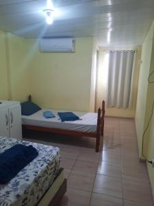 a small bedroom with two beds and a window at POUSADA LELÊ CONVENÇÕES in Recife