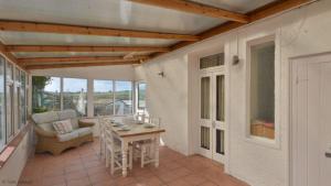 a patio with a table and chairs on a porch at Chycaron, Riviere Towans in Hayle