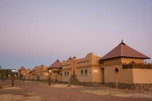 Bloemfontein的住宿－Emoya Basotho Lodge，土路上的一排建筑物