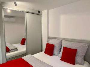 1 dormitorio con espejo y 1 cama con almohadas rojas en Mieszkanie w Dobrzeniu Wielkim, en Dobrzeń Wielki