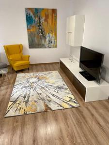 sala de estar con TV y silla amarilla en Mieszkanie w Dobrzeniu Wielkim, en Dobrzeń Wielki