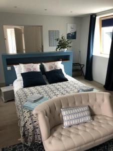 1 cama grande con sofá en una habitación en Aux Herbes Hautes en Fleurbaix