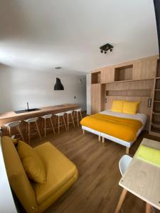 a bedroom with a bed and a couch and a kitchen at Hôtel La bonne hôtesse in Chambon-sur-Lac