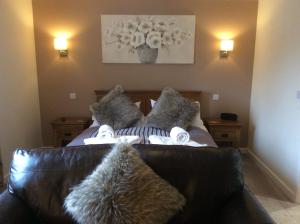 um sofá de couro com almofadas num quarto em The Garden Apartment a luxurious Rural Retreat em Wellington
