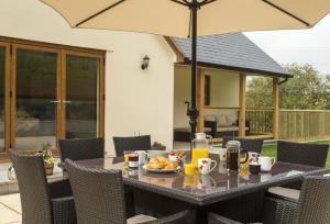 stół na świeżym powietrzu z parasolem i jedzeniem w obiekcie The Garden Apartment a luxurious Rural Retreat w mieście Wellington