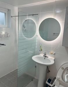 a bathroom with a sink and a glass shower at Gla Aewol in Jeju