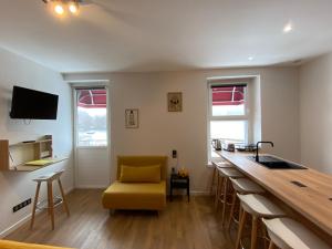 a kitchen with a counter and a yellow chair at Hôtel La bonne hôtesse in Chambon-sur-Lac