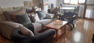 sala de estar con sofá, sillas y mesa en Apartamento Borja en Jaca