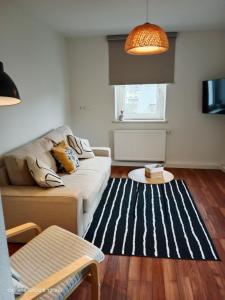 precioso apartamento 1B في أوغسطبورغ: غرفة معيشة مع أريكة وسجادة بيضاء وسوداء
