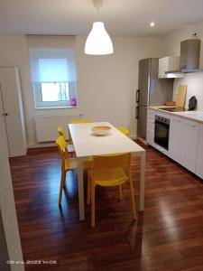 precioso apartamento 1B في أوغسطبورغ: مطبخ مع طاولة وكراسي صفراء في الغرفة