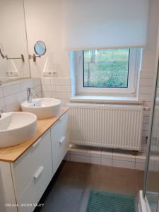 a bathroom with two sinks and a window at precioso apartamento 1B in Augustusburg