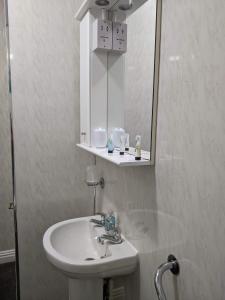 y baño con lavabo y espejo. en Kingswinford Guest House, en Paignton