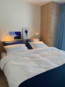 two beds in a room with white sheets and pillows at Ski in out Swiss Alps Chalet Charelle by Jolidi in Nendaz