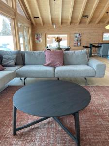 a living room with a couch and a table at Ski in out Swiss Alps Chalet Charelle by Jolidi in Nendaz