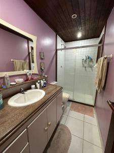 a bathroom with a sink and a glass shower at Casa da Ogiva in Cabo Frio