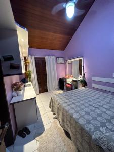 a bedroom with a bed and a purple wall at Casa da Ogiva in Cabo Frio