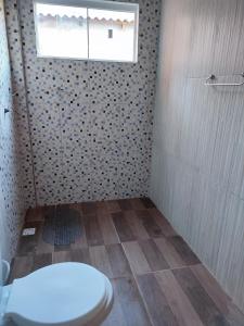 a bathroom with a toilet and a shower with a window at Casa Silvano's II in Foz do Iguaçu