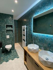 a bathroom with a sink and a toilet and a mirror at Hôtel La bonne hôtesse in Chambon-sur-Lac +59 photos