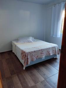 1 dormitorio con cama con colcha de flores en Casa Silvano's II, en Foz do Iguaçu