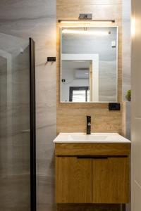 een badkamer met een wastafel en een spiegel bij Boutique Central old town Apartment in Beer Sheva
