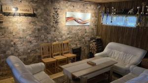 a living room with couches and a table and a fireplace at Ojaääre puhkemaja in Kuldre +8 photos