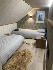 - une chambre avec 2 lits et une table avec un tapis dans l'établissement Ojaääre puhkemaja, 