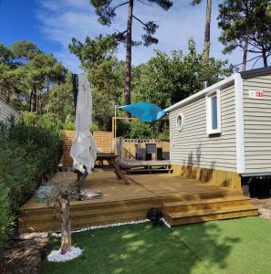 a wooden deck next to a tiny house at Mobile-Home 6 personnes Cap Ferret in Claouey