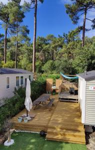 a wooden deck with a bench and a swing at Mobile-Home 6 personnes Cap Ferret in Claouey