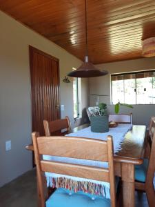 ein Esszimmer mit einem Tisch und einer Holzdecke in der Unterkunft Nosso Pátio - Chalé na Montanha in Rancho Queimado