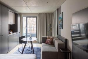 uma pequena sala de estar com um sofá e uma mesa em numa I Stark Rooms & Apartments em Munique