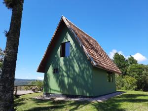 uma casa verde com telhado castanho em Nosso Pátio - Chalé na Montanha em Rancho Queimado