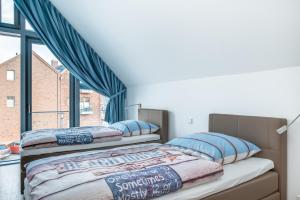 2 Betten in einem Zimmer mit Fenster in der Unterkunft Willem und Konsorten - Hafenflair in Heiligenhafen
