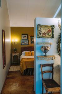 a bedroom with a bed and a chair in it at Blue Bell Guesthouse in Tzaneen