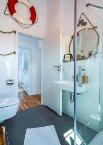 a bathroom with a glass shower and a toilet at Willem Waterkant in Heiligenhafen