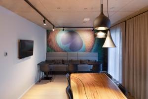 a dining room with a table and a painting on the wall at numa I Stark Rooms & Apartments in Munich