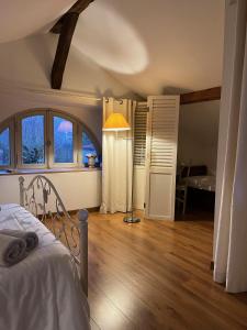ein Schlafzimmer mit einem Bett und einer Lampe in einem Zimmer in der Unterkunft Gîte Le Pavillon in Les Sorinières