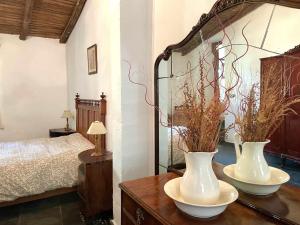 1 dormitorio con 2 jarrones blancos sobre una mesa de madera en La Alberguería complejo rural, en Cañamero