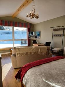 a living room with a bed and a couch and a desk at Erraid Lodge in Fort Augustus