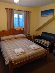 1 dormitorio con 1 cama con 2 toallas en Kingswinford Guest House, en Paignton