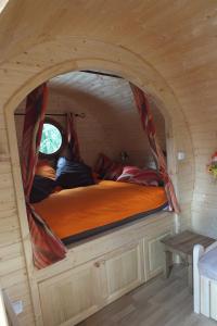 a bed in a small room in a tiny house at roulotte viticole in Xertigny