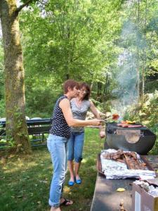 a man and a woman cooking food on a grill at roulotte viticole in Xertigny