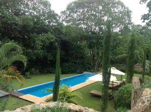 a swimming pool in a yard with trees at Lake Duluti Lodge in Arusha