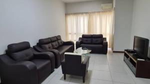 a living room with two leather couches and a tv at Sekinchan Paddy via Seaview Home in Sekincan