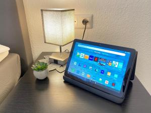 a laptop computer sitting on a desk next to a lamp at 3 Zimmer Apartment in S-Bahn Nähe, 76 qm, max 5 Pers, 30qm Dachterasse, Garage, Internet 1000 MBit in Gärtringen