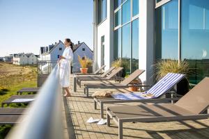 une femme debout sur le balcon d'un bâtiment dans l'établissement TUI BLUE Sylt, à Rantum