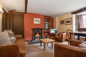 a living room filled with furniture and a fireplace at The Mountain Cottages - Pelton Wheel in Coniston