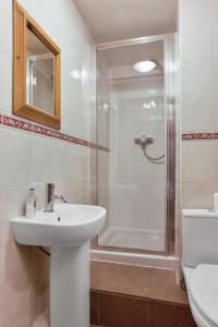a bathroom with a sink and a shower at The Mountain Cottages - Pelton Wheel in Coniston