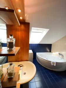 a bathroom with a tub and a sink at Fado Apartments Lendava in Lendava