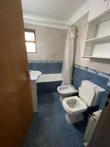 a bathroom with two toilets and a sink and a tub at Apartamentos Flores in Buenos Aires