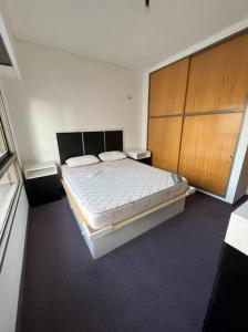 1 dormitorio con 1 cama y armarios de madera en Apartamentos Flores en Buenos Aires